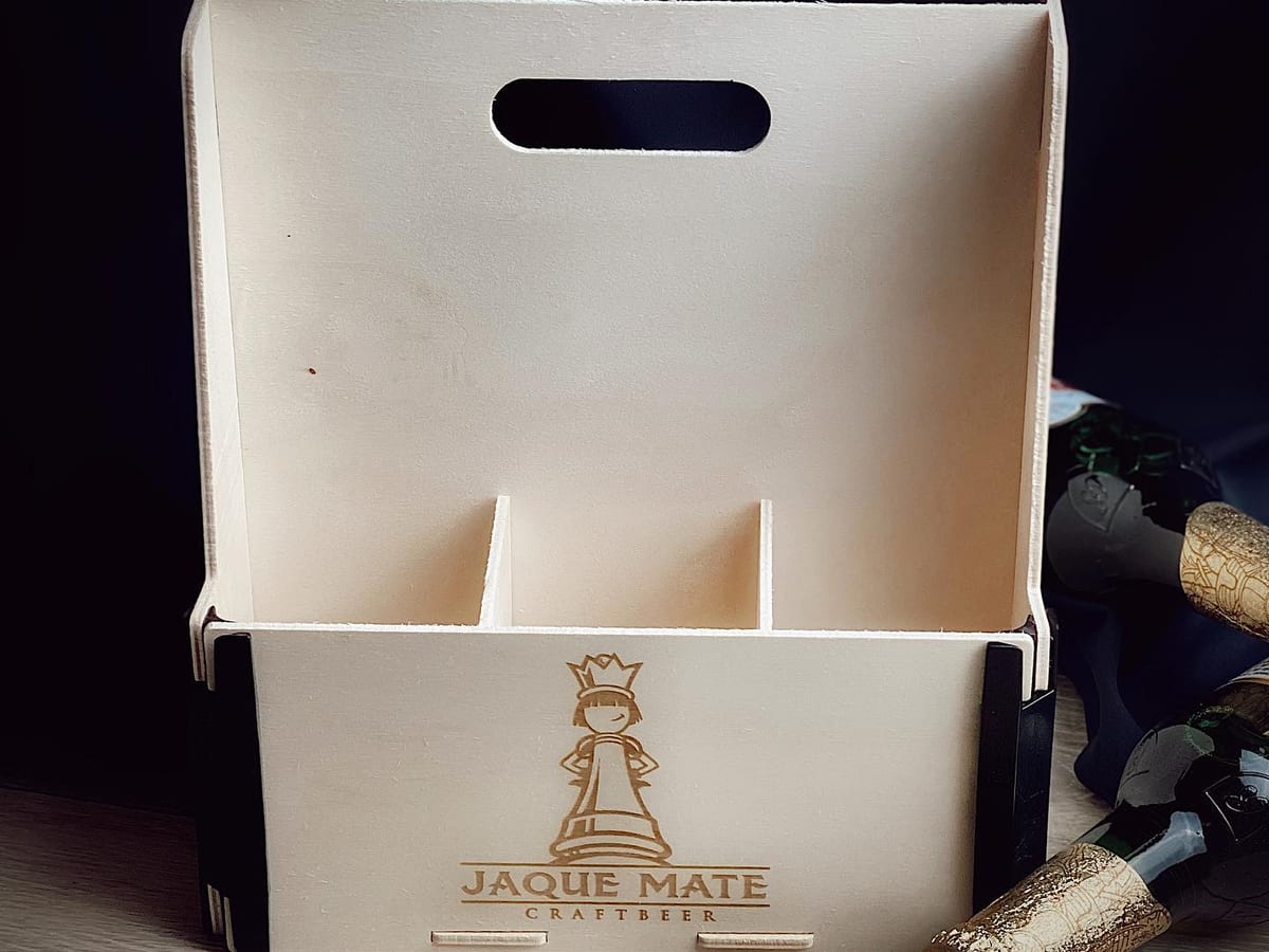 Caja con asa para seis botellines con separadores y el logo de una cervecera artesana grabado en el frontal
