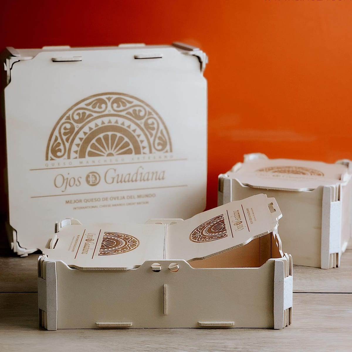 Trois boîtes en bois d’une fromagerie de manchego, avec son logo gravé sur le couvercle et la face avant
