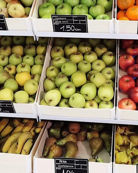 Obstauslage mit Sincla-Holztabletts voller grüner Äpfel, Bananen und Birnen