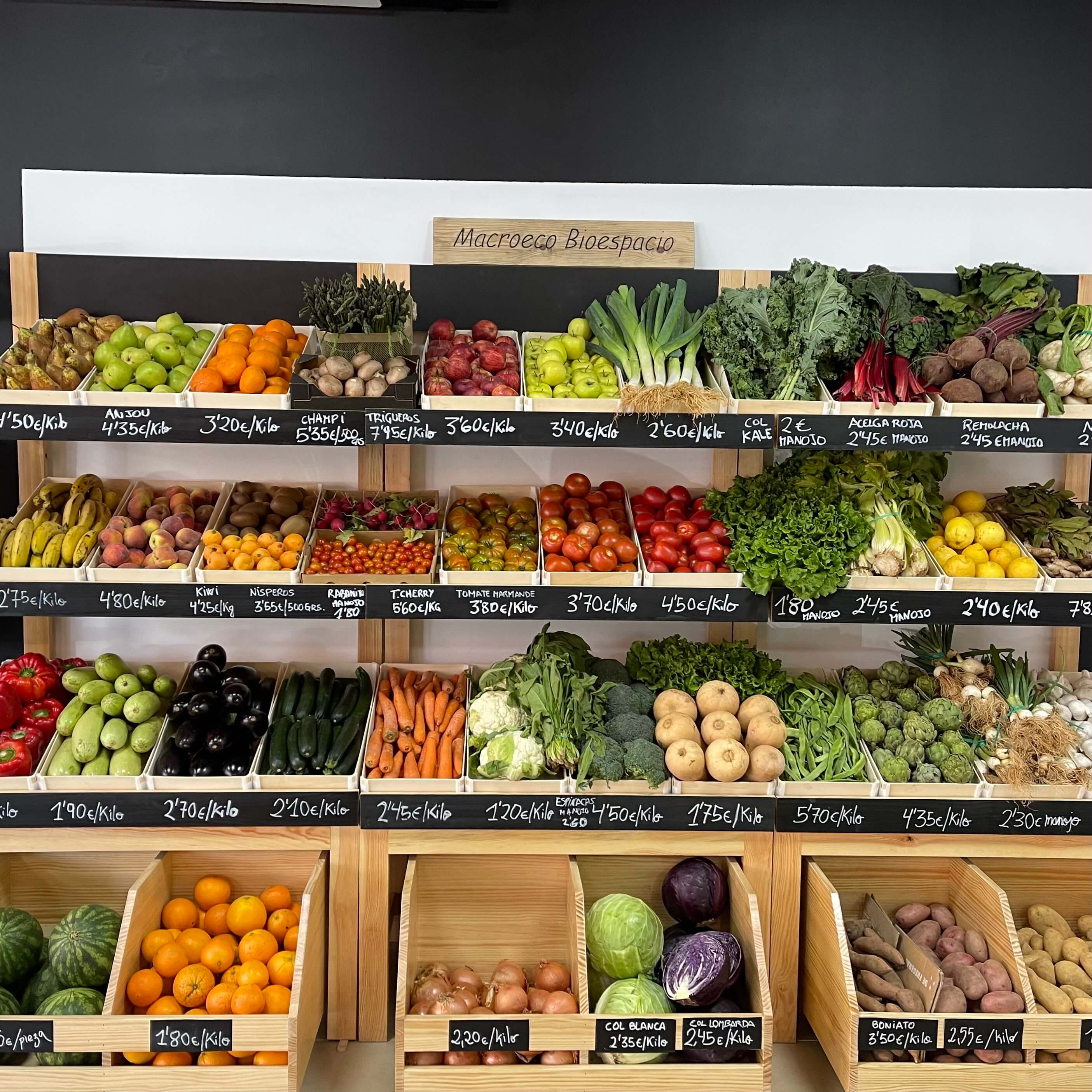 Frutería con cajas de madera llenas de fruta y verdura en las estanterías