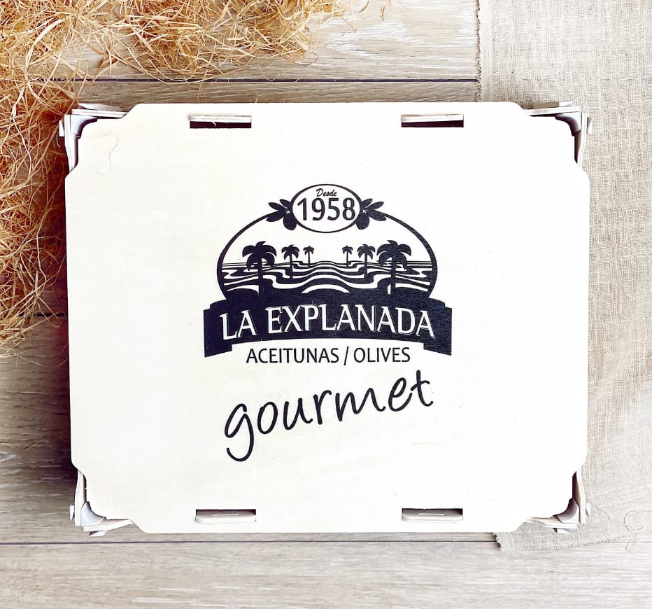 Tapa de una caja de madera con el logo de una marca de aceitunas gourmet impreso en negro