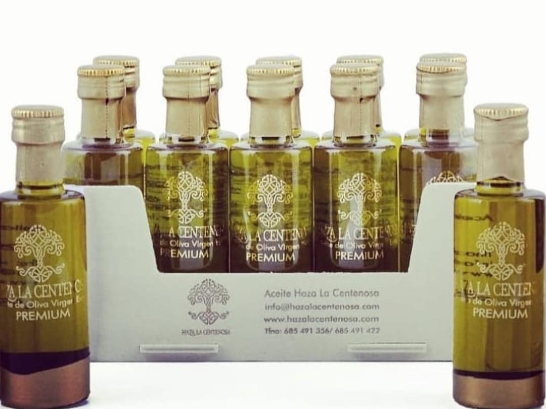 Botellitas de aceite de oliva virgen extra en una bandeja de madera con la marca impresa en el frontal