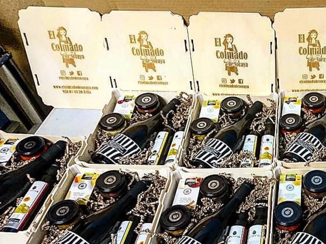 Cajas con tapa de madera llenas de lotes gourmet, con la marca de la tienda grabada en las tapas