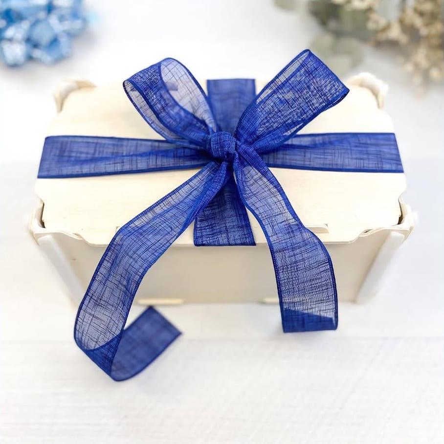 Caja de madera con tapa cerrada con un gran lazo de organza azul