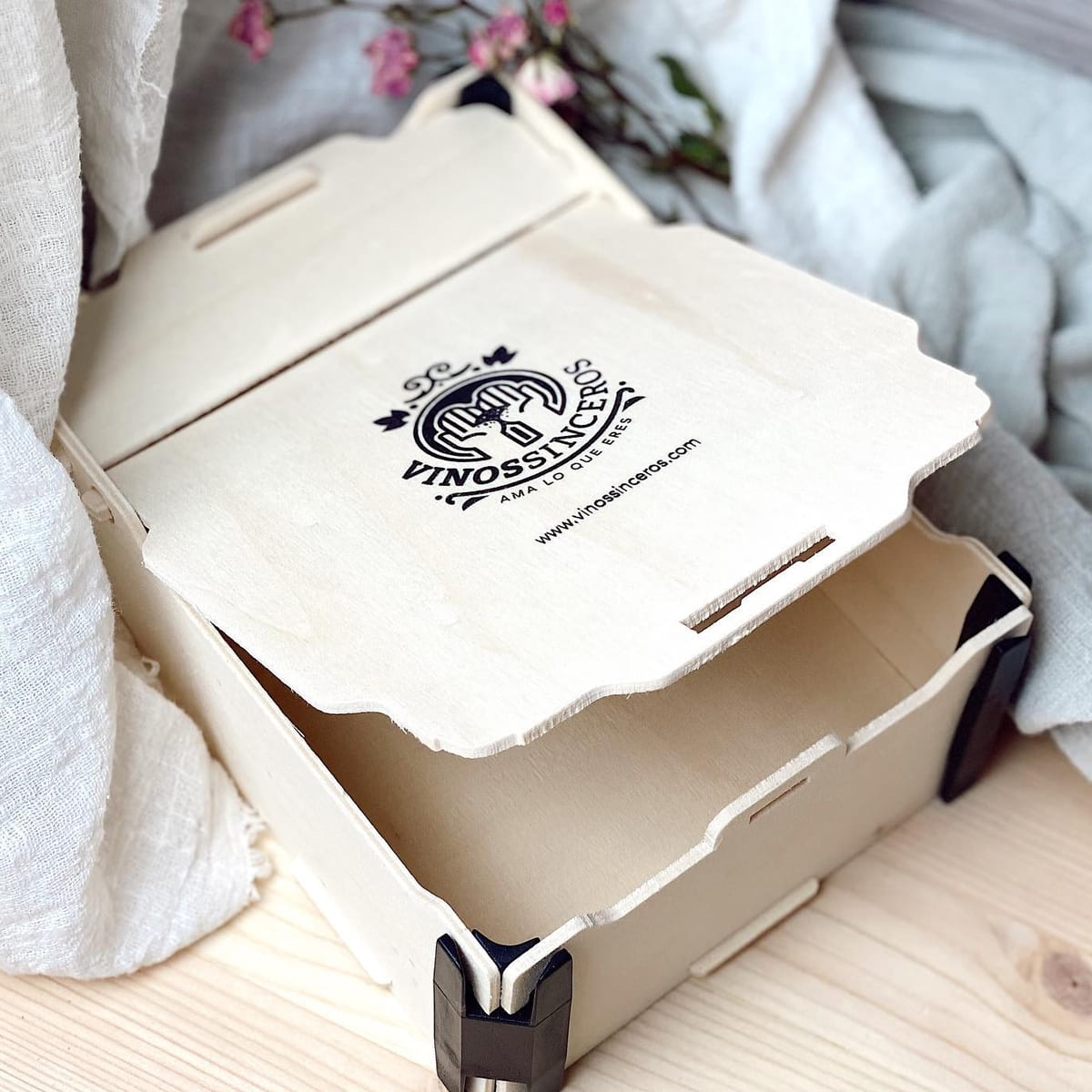 Half-open hinged box with a wine shop’s logo printed in black on the lid